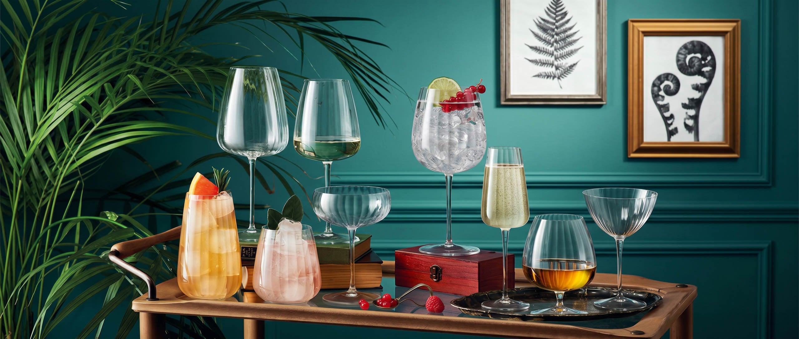 Table with various Optica glasses containing drinks against a teal wall with framed artwork