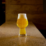 Birrateque Stout Beer glass filled with light beer standing on a marble surface and a dark background