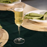Grandioso flute filled with a sparkling wine standing on a set table with green and natural hues