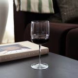 Clear wine glass with red wine on a table with a blurred background