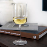 Wine glass with white wine on a book