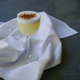 Cocktail with foam and cinnamon on a white cloth