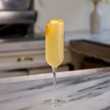 Cocktail in a tall glass with a blurred kitchen background