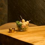 Sublime Thermic double-wall bowl filled with greens and skewers standing on a wooden table and a dark background
