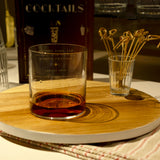 Top Class DOF glass filled with whisky, standing on a wooden tray with décor in the background
