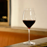 Vinea Cannonau wine glass filled with red wine on a soft ivory background