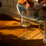 Wine glass with white wine on a wooden table with autumn decorations
