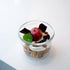 Lock-Eat Canning & Food Jar XL filled with an appetizing dessert of cream, cookies and finished with a miniature caramelized apple, chocolate chunks and a leaf, standing on a white surface