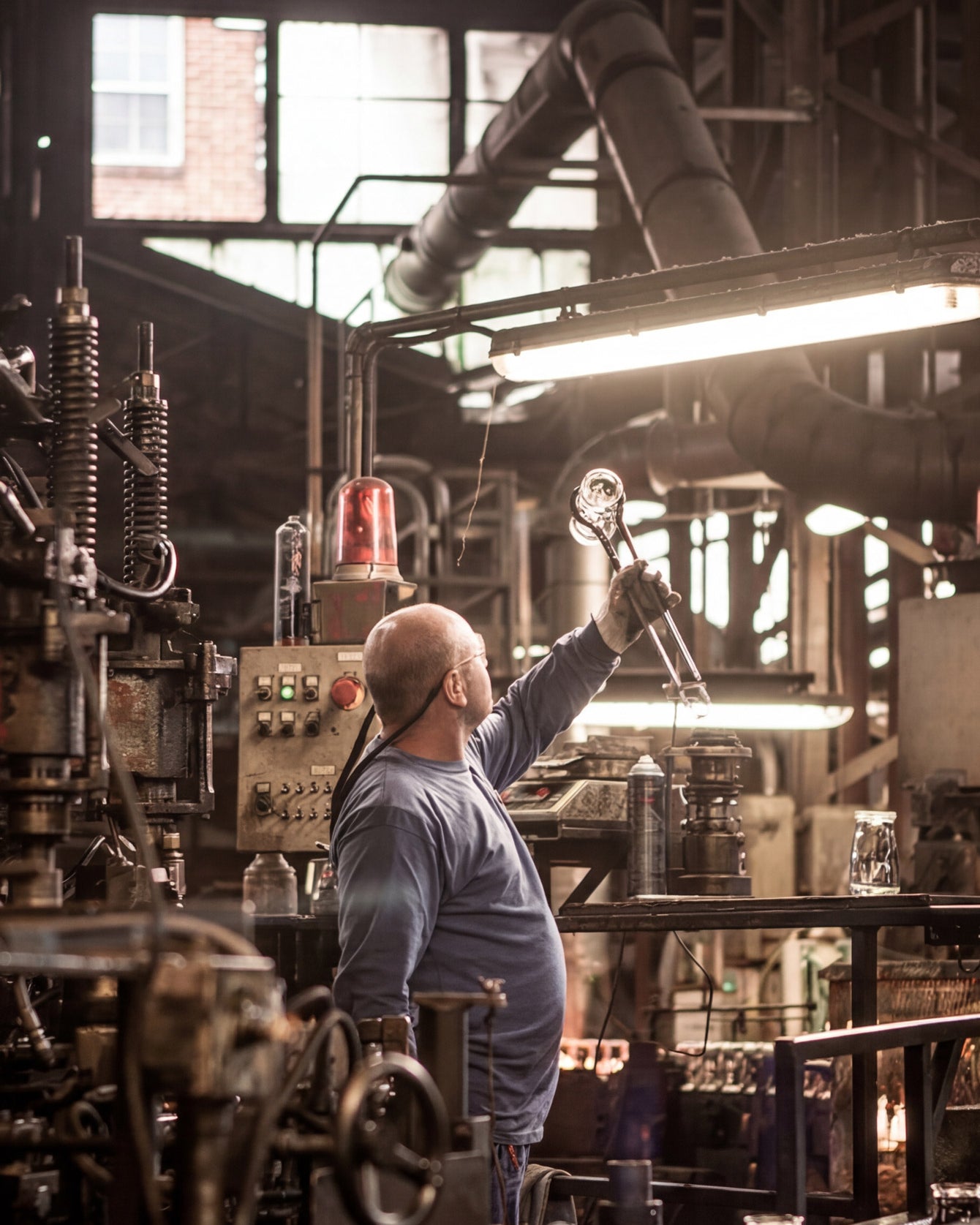 Person working in a large industrial setting with machinery and equipment.
