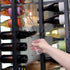 Hand holding a Talismano Italian Premium Bordeaux Red Wine Glass filled with a red wine on a wine cellar background