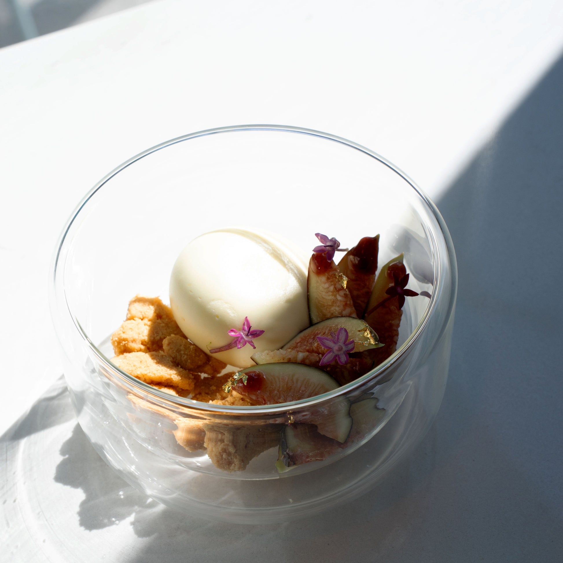 Thermic Sublime Double Wall Dessert Bowl filled with appetizing dessert with figs and cookies finished with little flowers and gold flakes, standing on a white surface