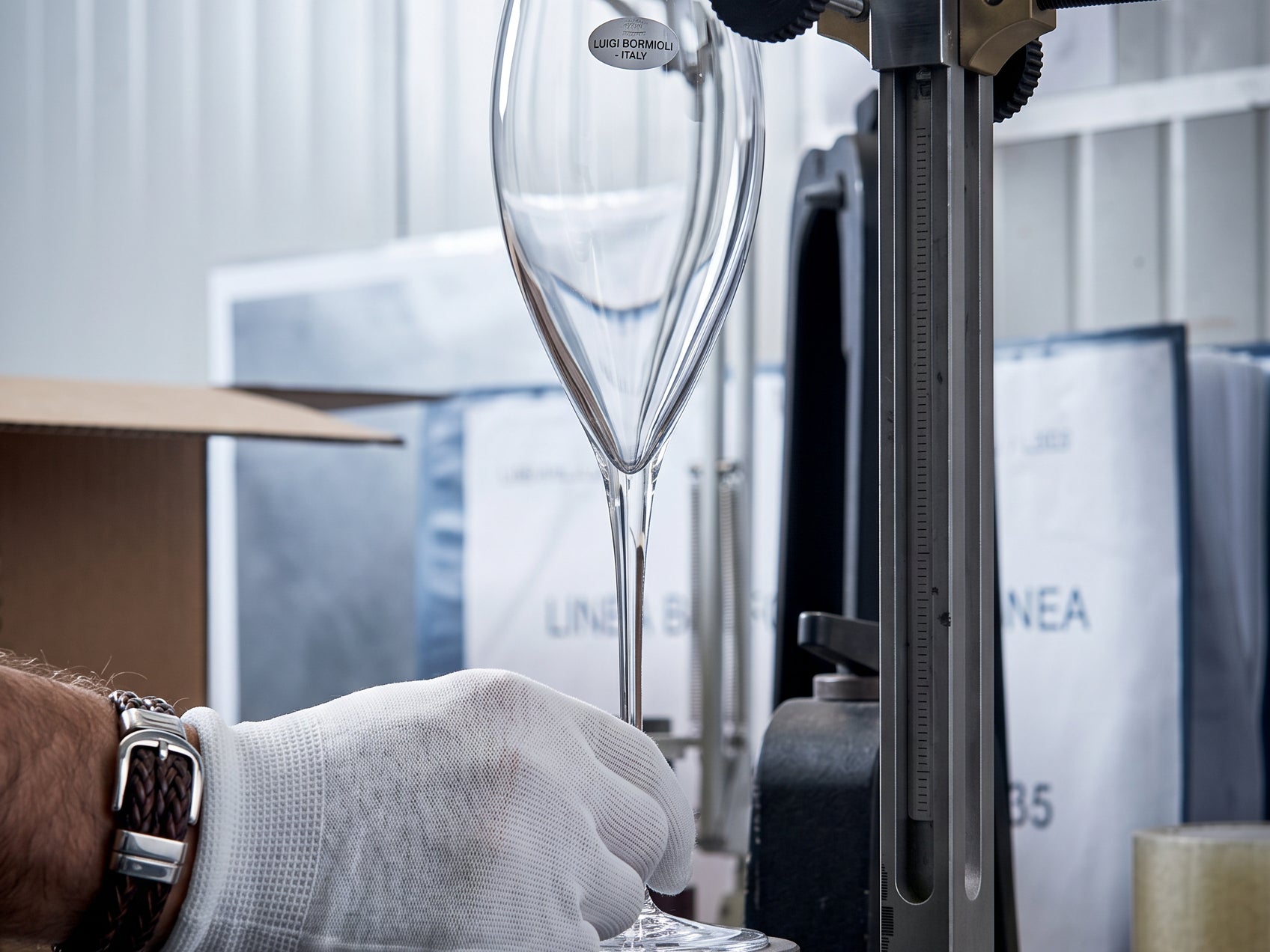 Person wearing a white glove operating a piece of laboratory equipment.