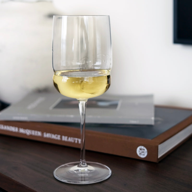 Wine glass with white wine on a book