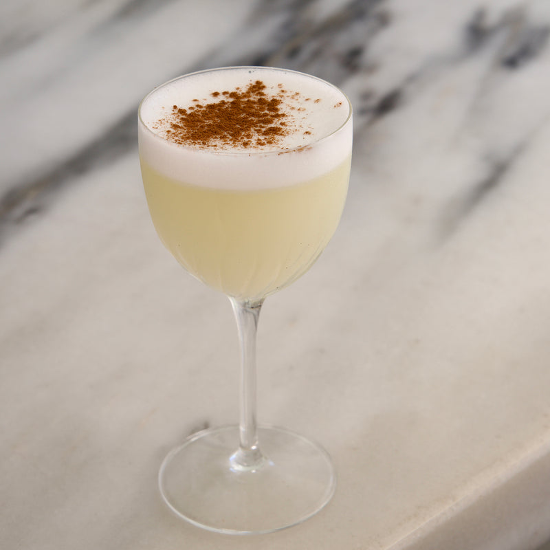 Cocktail with foam and cinnamon on a marble surface