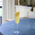 Cocktail in a glass on a table with a blurred kitchen background