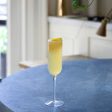 Cocktail in a glass on a table with a blurred kitchen background