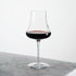 Tentazioni Bordeaux Red Wine Glass filled with red wine standing on a light marble surface and a white background