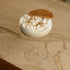 Glass of creamy dessert with a cookie on top on a marble surface